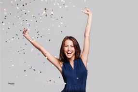 Woman smiling and celebrating with confetti above her