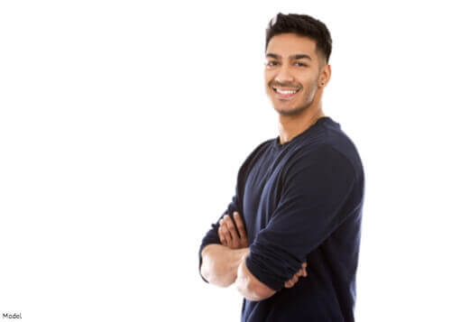 Man standing up smiling with arms crossed
