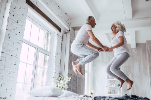 Man and woman jumping on the bed