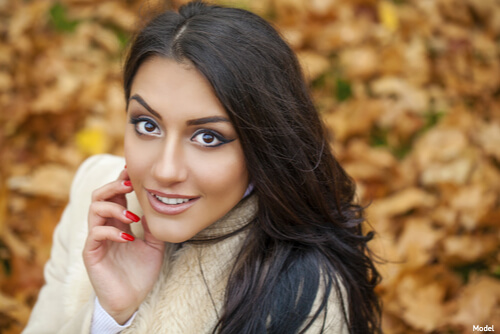 Woman with great skin smiling laying in the leaves