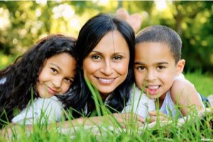 Mother laying in the grass with her children