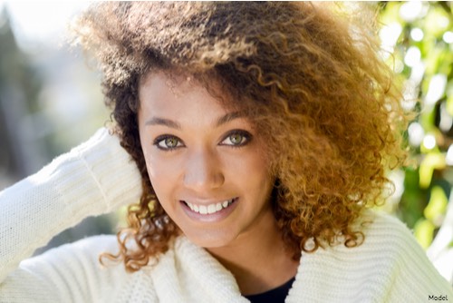 Woman with short brown hair smiling outdoors