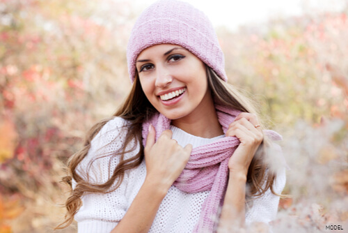 Woman in a pink hat and scarf smiling
