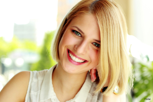 Woman with a blonde bob smiling outdoors