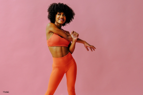 Confident woman in activewear stretching her arms