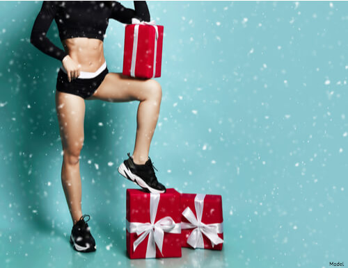 Woman wearing workout clothes with Christmas gifts