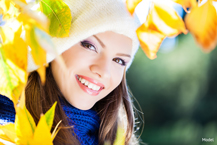 woman in a white hat standing under a tree