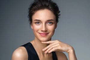 A woman smiling and showing the results of a BBL photofacial in Mill Valley