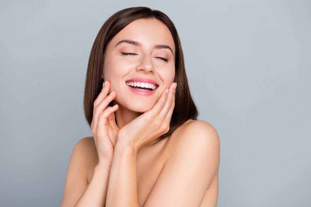 A woman touching her cheeks after microneedling in Mill Valley