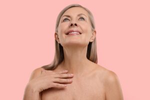 A woman touching her décolletage after Secret RF microneedling
