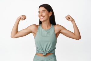 A woman smiling and flexing her muscles after truSculpt® Flex+ in Mill Valley